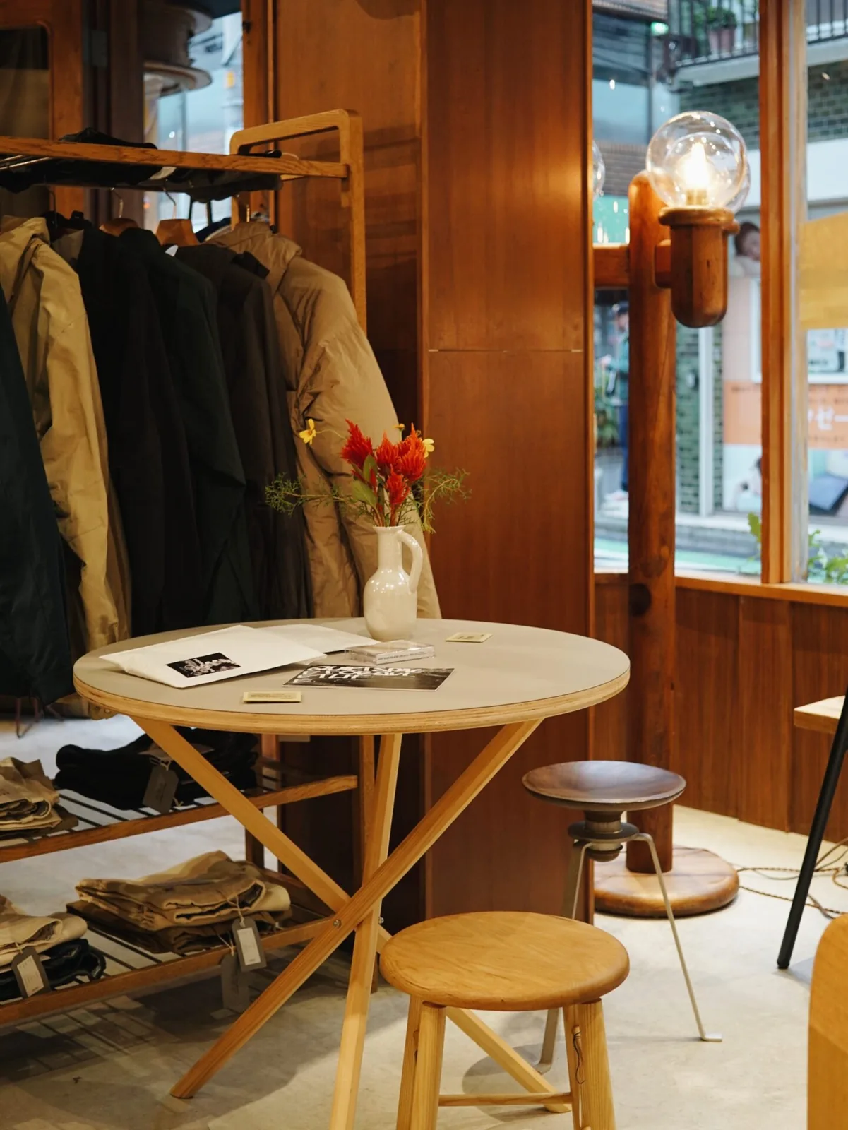 BULLPENの店内。丸テーブルとスツール、衣類